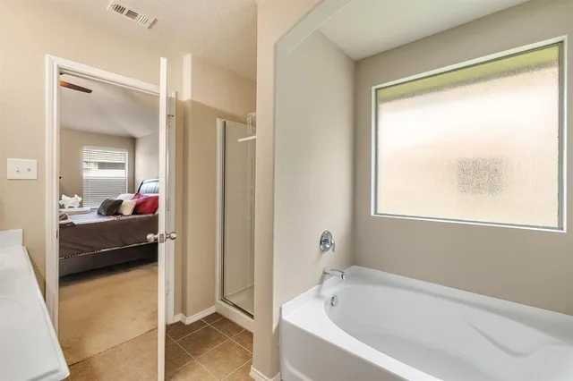 a bathroom with a tub shower and sink