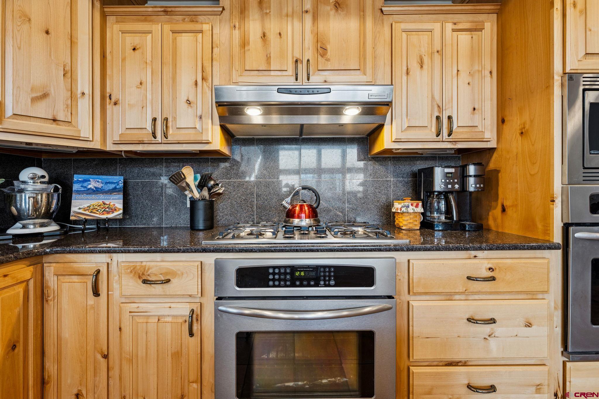 191 Aspen Drive Durango, CO 81301 - Photo 7 of 43 a stove top oven sitting inside of a kitchen and granite counter tops