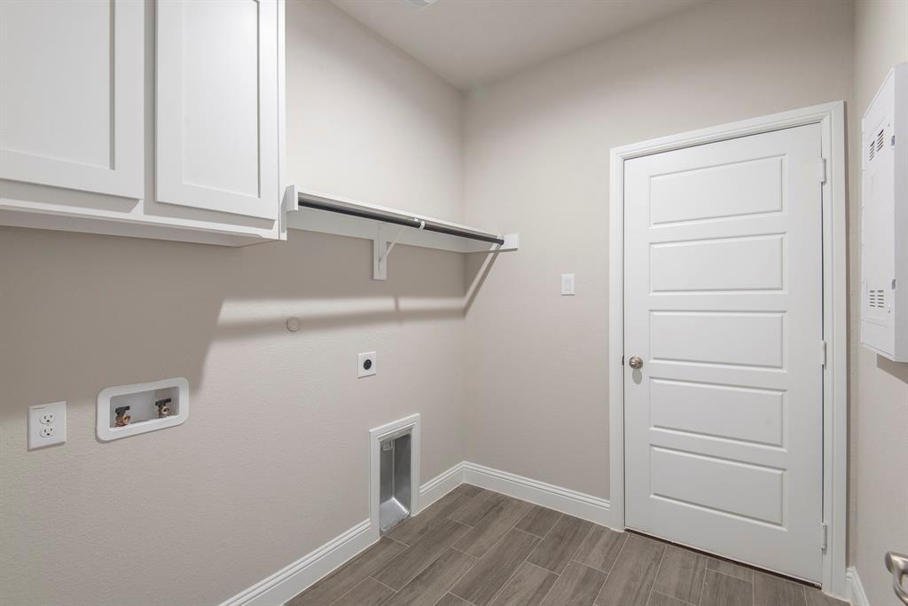 2301 Ruff Road Denton, TX 76205 - Photo 20 of 23 Utility room featuring wood-finish tile flooring, white shaker-style cabinetry, and a clothes rod