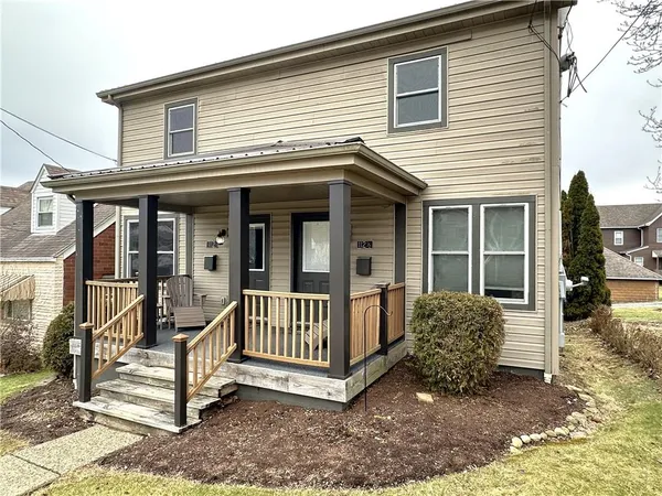 a view of a house with a yard and porch