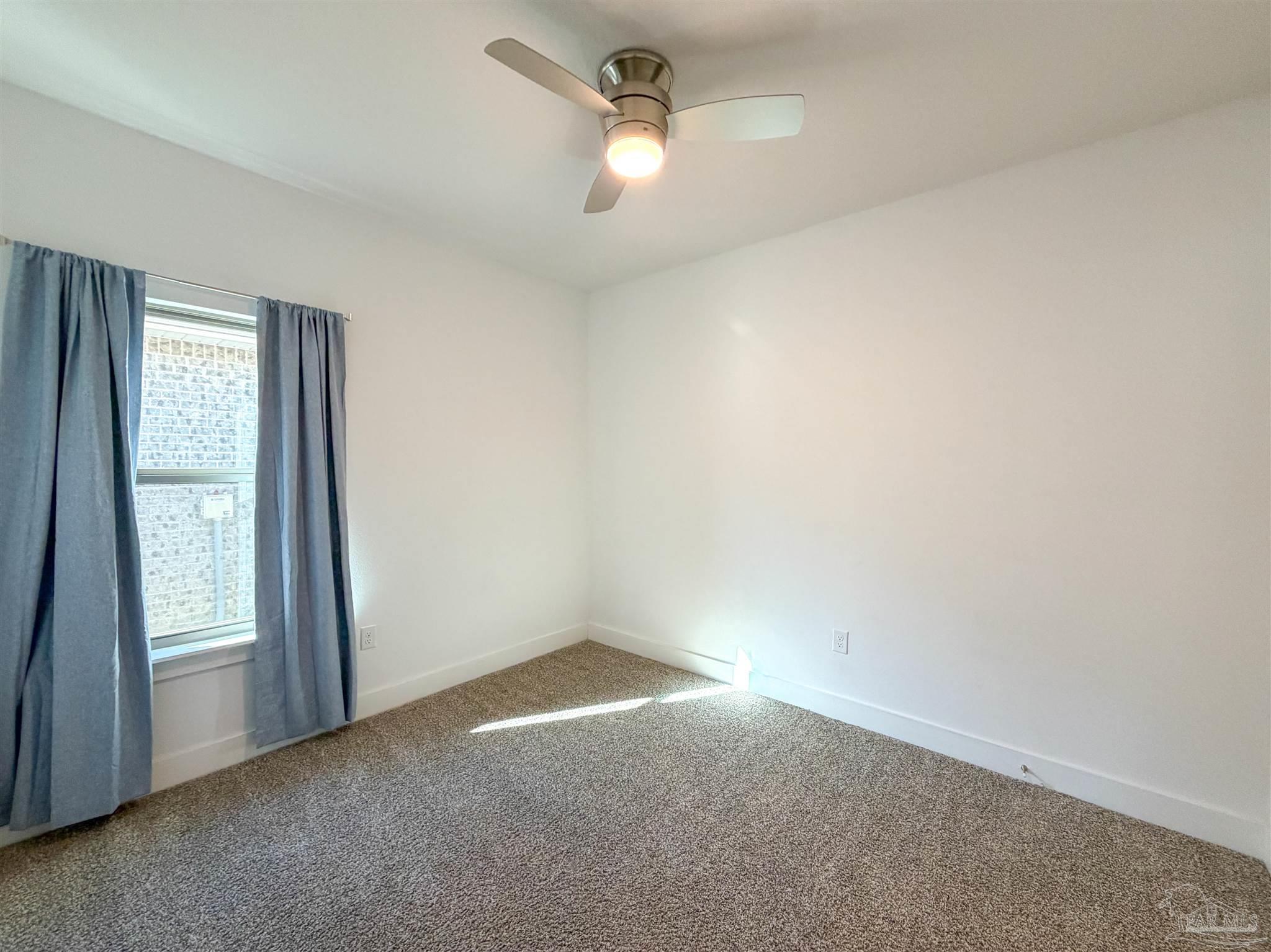 7429 Jamesville Road Pensacola, FL 32526 - Photo 19 of 24 an empty room with windows and ceiling fan