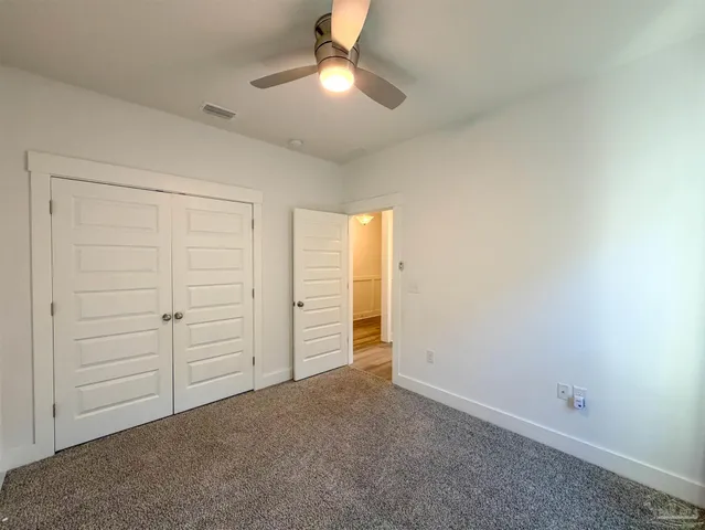 an empty room with closet and windows
