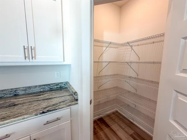 a bathroom with a granite countertop sink and white cabinets