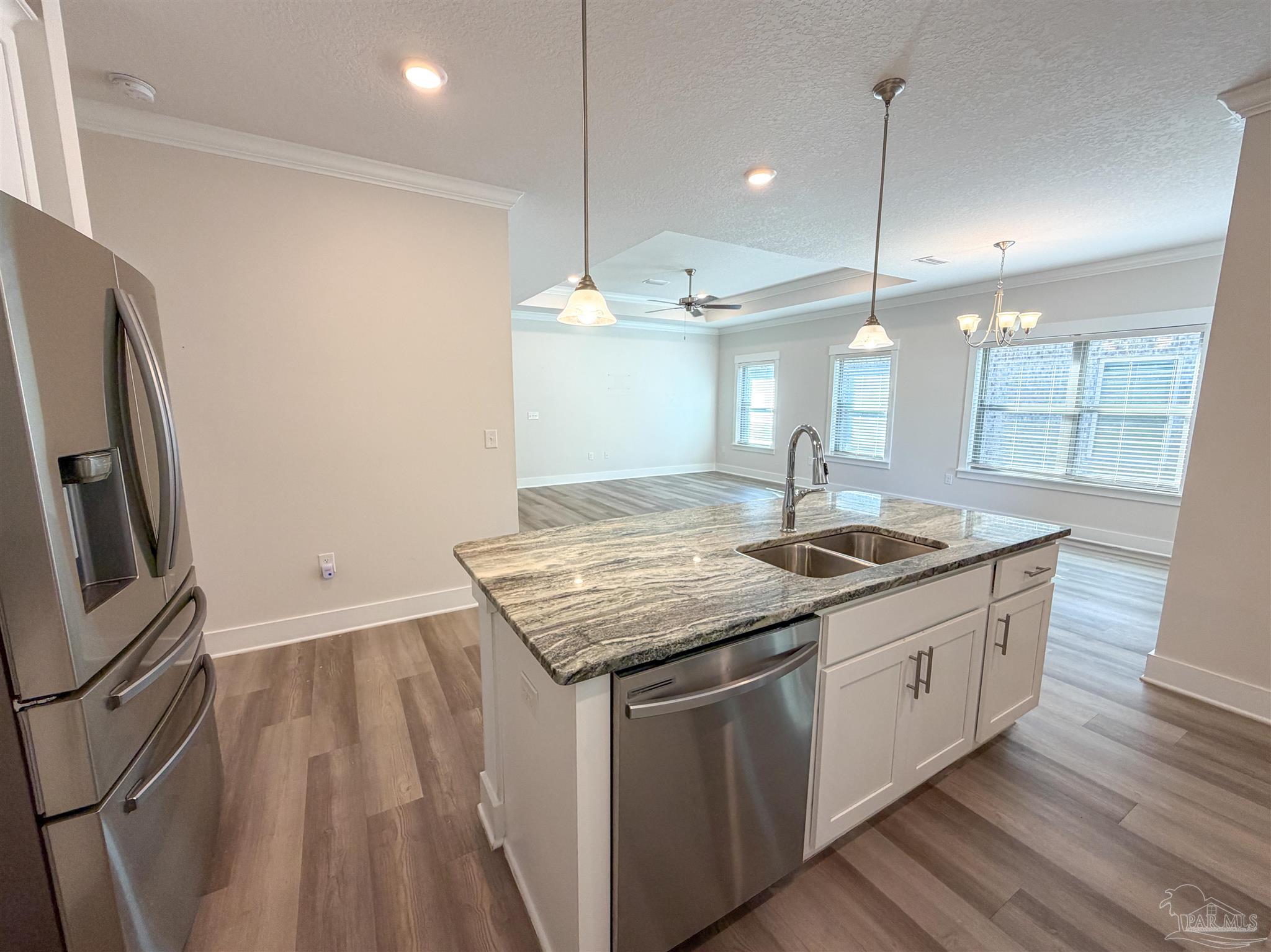7429 Jamesville Road Pensacola, FL 32526 - Photo 7 of 24 a kitchen with stainless steel appliances granite countertop a sink a stove a refrigerator and a wooden floor