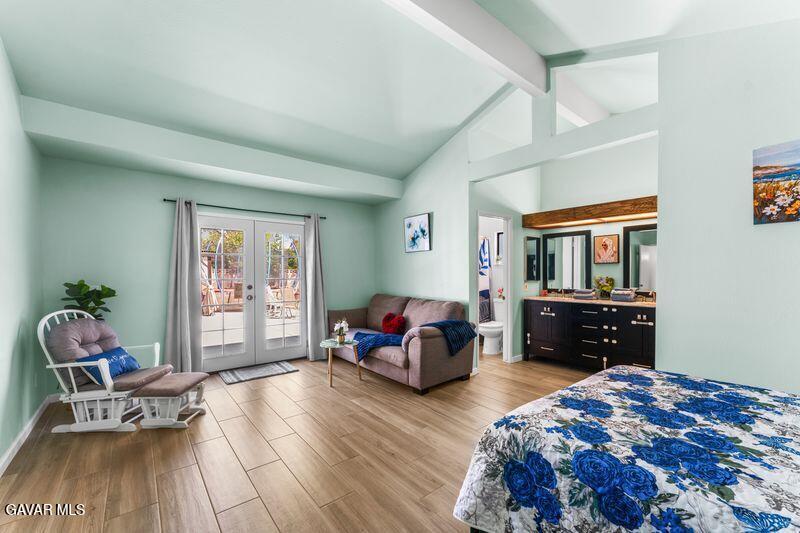 44246 Ruthron Avenue Lancaster, CA 93536 - Photo 17 of 31 a bedroom with a bed and wooden floor