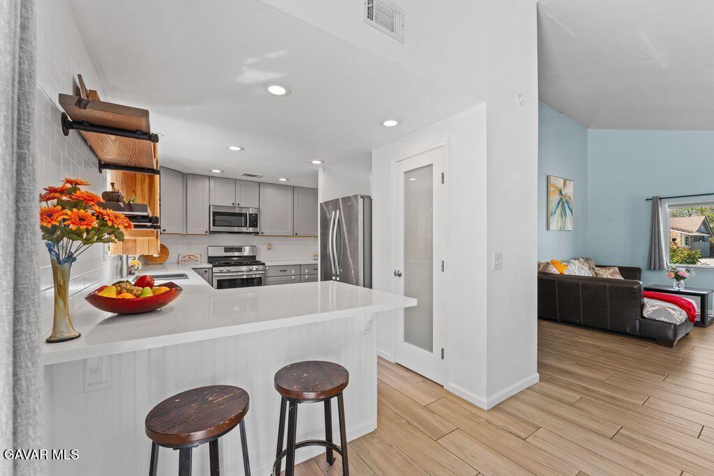 44246 Ruthron Avenue Lancaster, CA 93536 - Photo 24 of 31 a kitchen with stainless steel appliances a stove a sink a refrigerator and cabinets