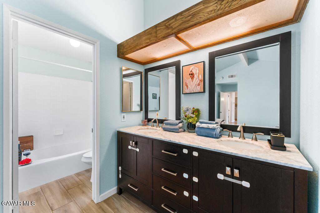 44246 Ruthron Avenue Lancaster, CA 93536 - Photo 5 of 31 a bathroom with a sink vanity tub and a mirror
