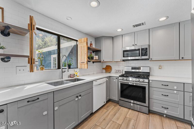 44246 Ruthron Avenue Lancaster, CA 93536 - Photo 10 of 31 a kitchen with a sink stove and cabinets