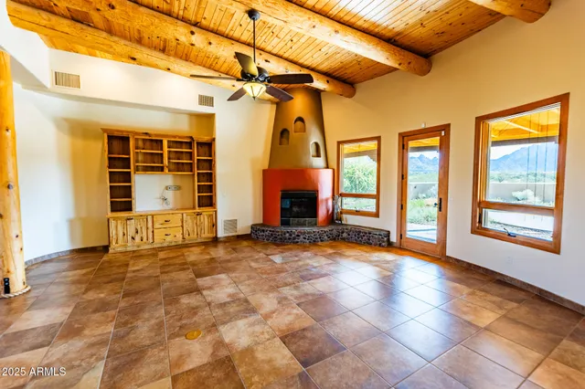 a view of an empty room with a fireplace and windows