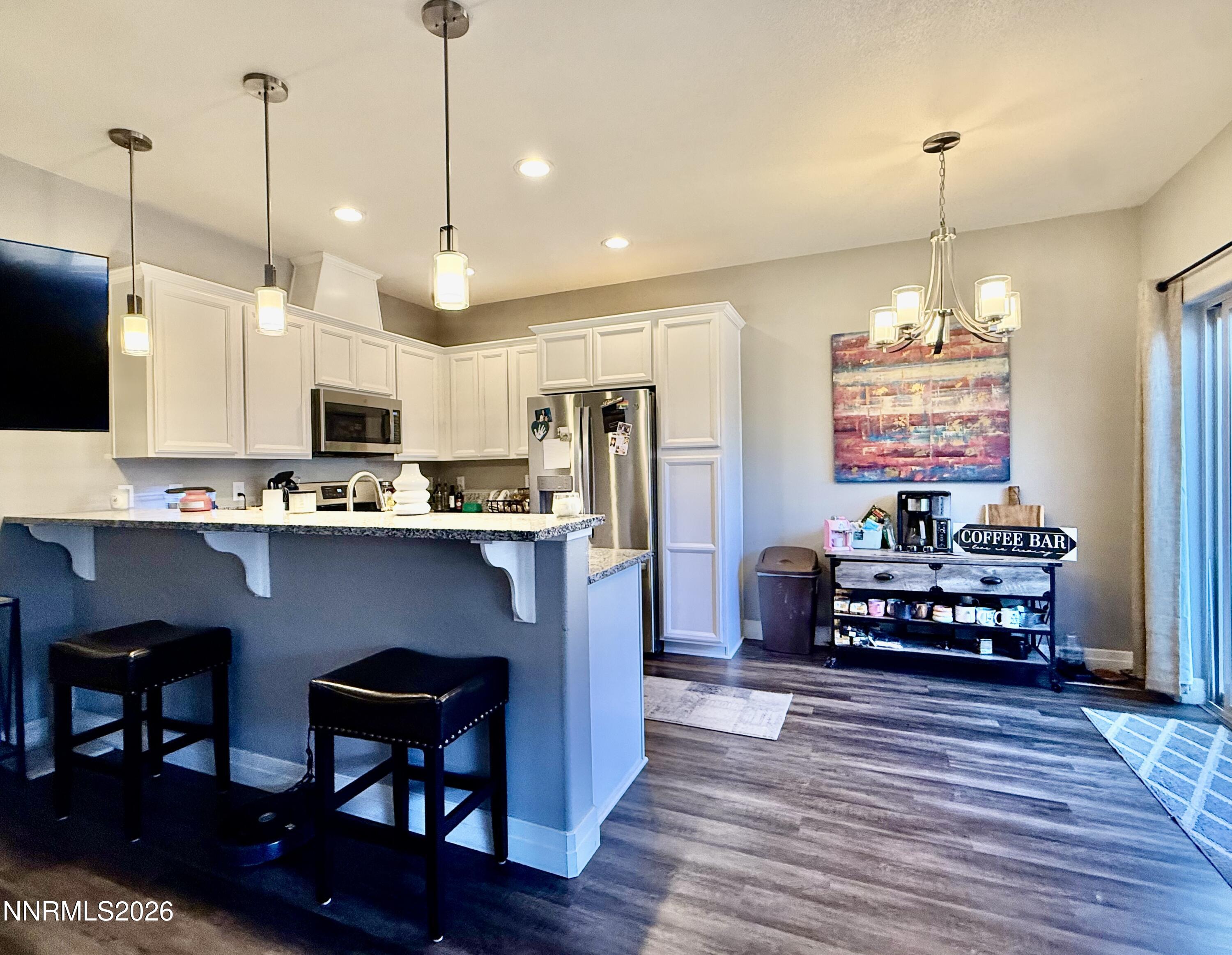 1310 Handelin Road Carson City, NV 89706 - Photo 11 of 40 a kitchen with kitchen island granite countertop a stove a refrigerator a oven a dining table and chairs with wooden floor