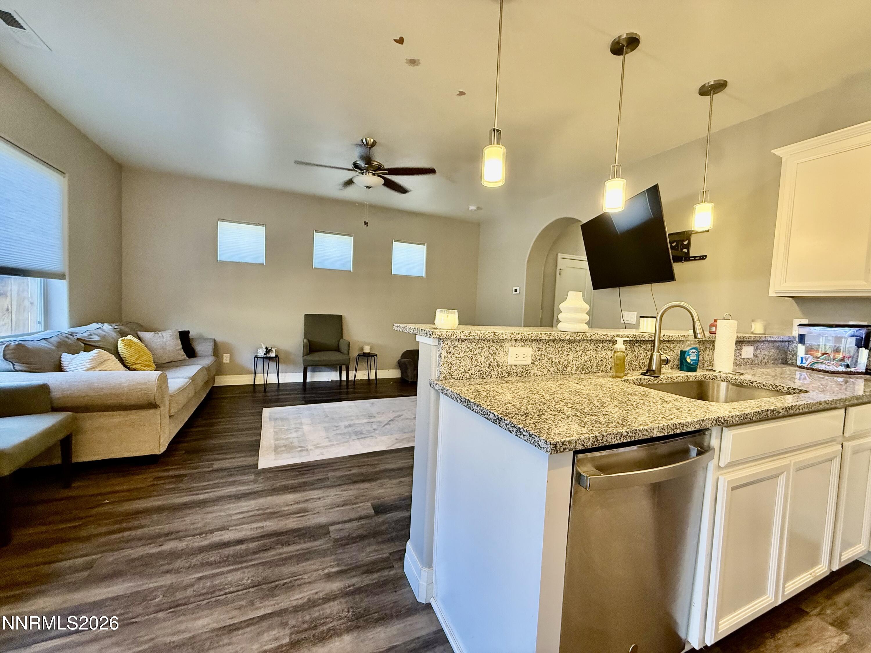 1310 Handelin Road Carson City, NV 89706 - Photo 14 of 40 a living room with stainless steel appliances kitchen island granite countertop a sink dishwasher and a flat screen tv