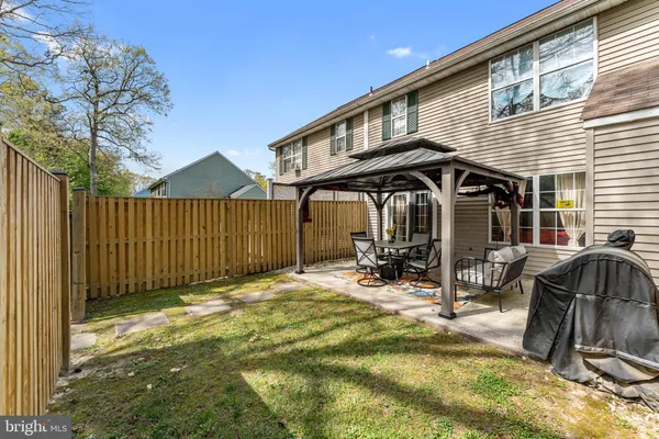 a view of a yard with trees and wooden fence