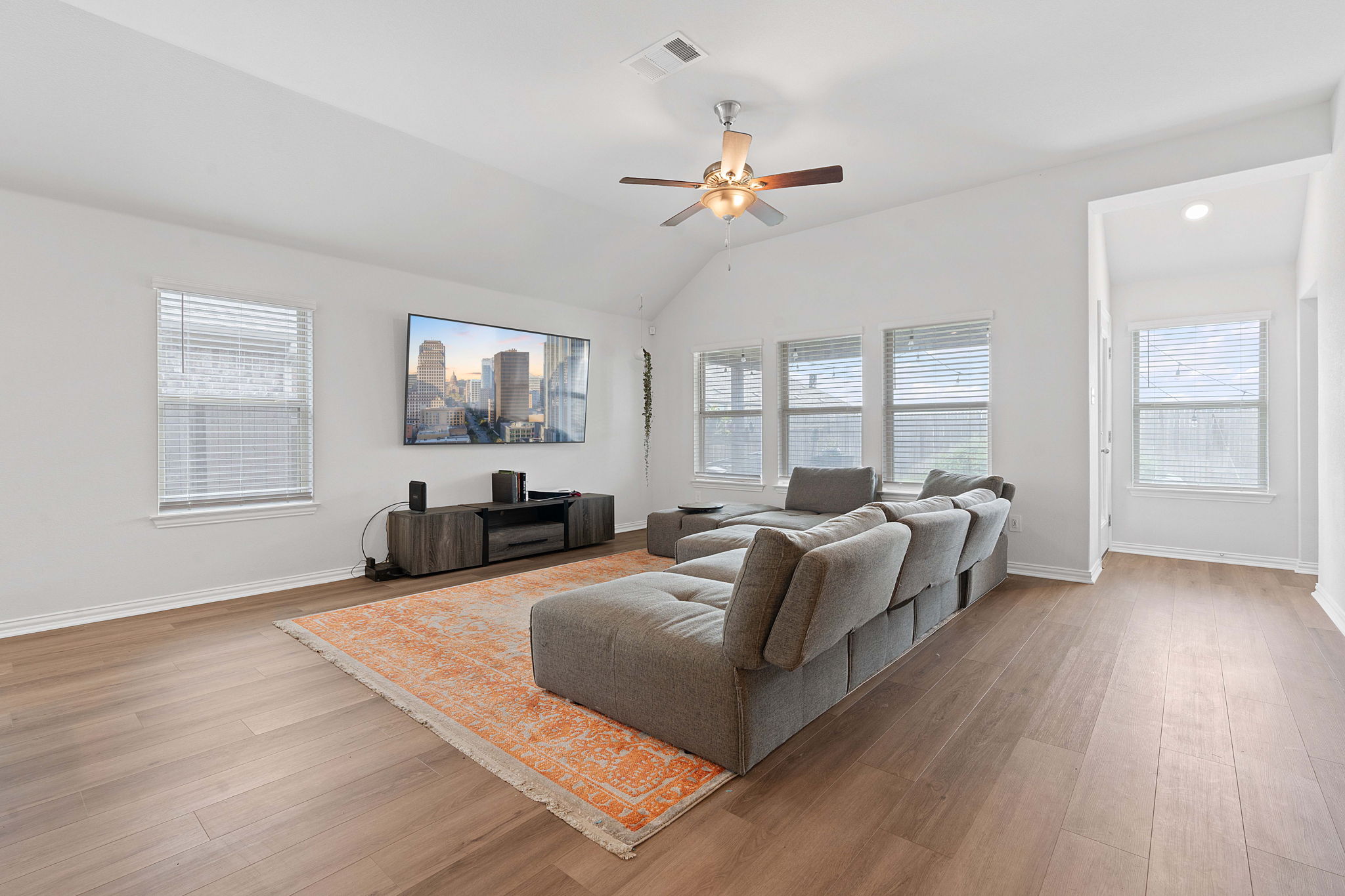 213 Treasure Trove Path Kyle, TX 78640 - Photo 11 of 29 Living area with light wood-type flooring, a ceiling fan, and vaulted ceiling