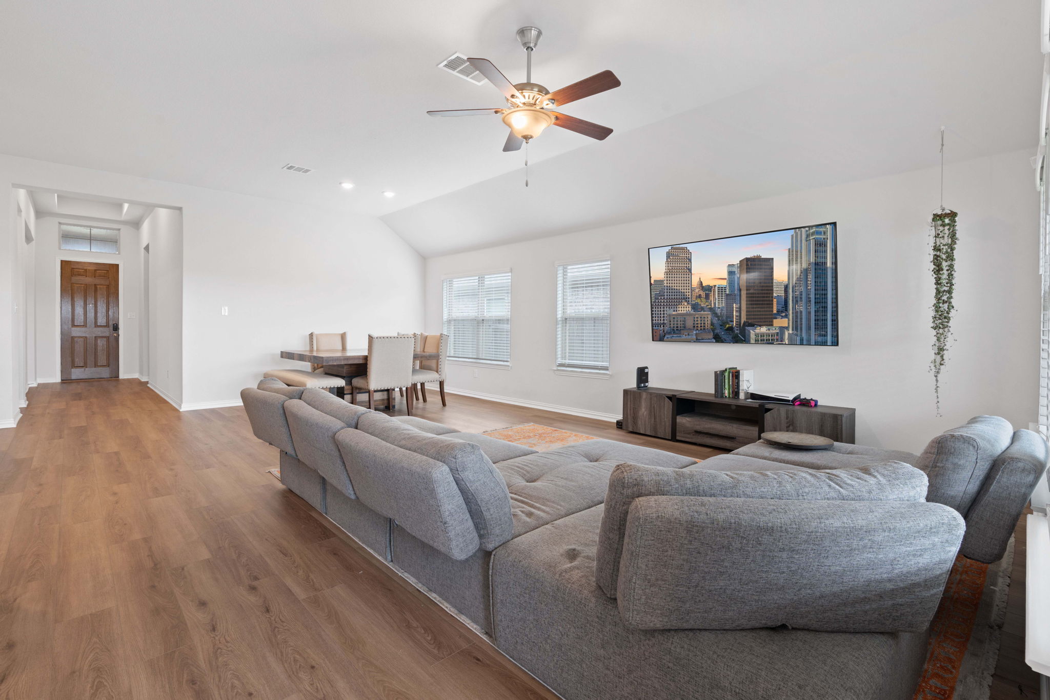 213 Treasure Trove Path Kyle, TX 78640 - Photo 12 of 29 Living room with ceiling fan, wood finished floors, and vaulted ceiling