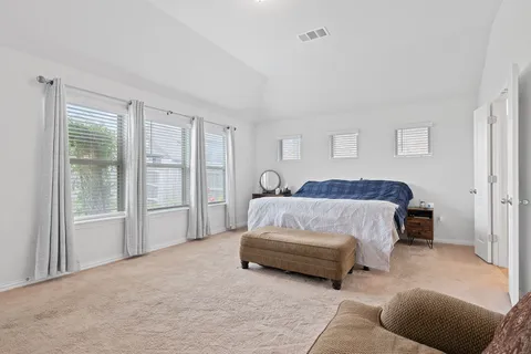 a spacious bedroom with a bed and a couch