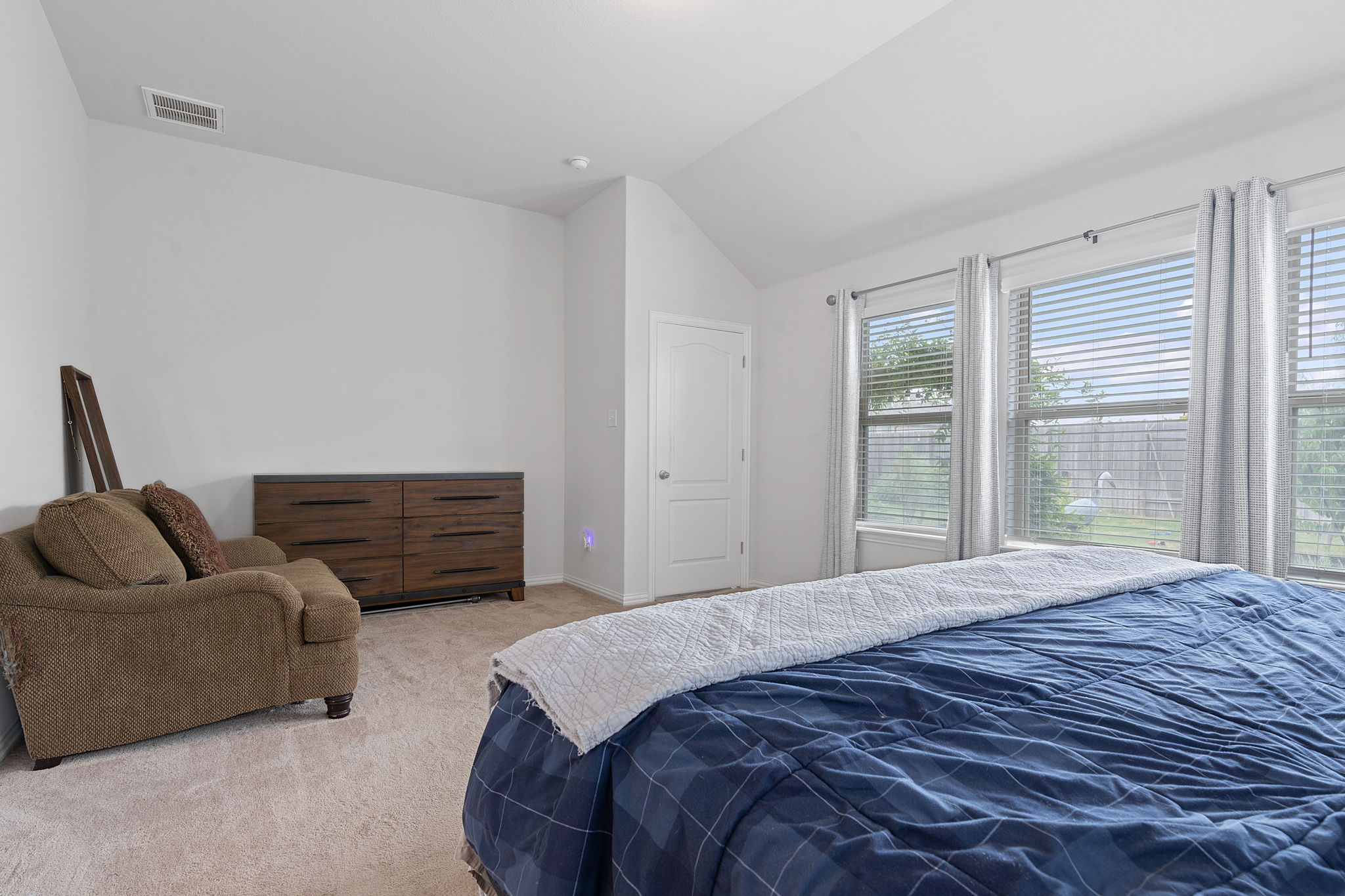 213 Treasure Trove Path Kyle, TX 78640 - Photo 20 of 29 Bedroom with vaulted ceiling and light colored carpet
