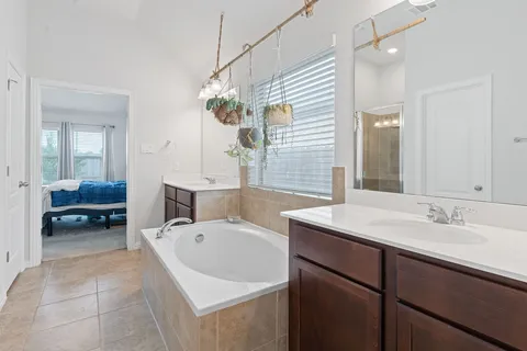 a spacious bathroom with a sink a mirror and a bathtub