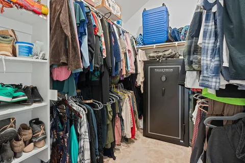 a view of walk in closet with clothes and shoes