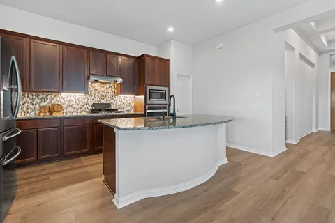 a kitchen with stainless steel appliances granite countertop a sink stove and refrigerator