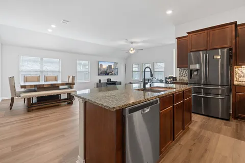 a kitchen with stainless steel appliances granite countertop a sink stove and refrigerator