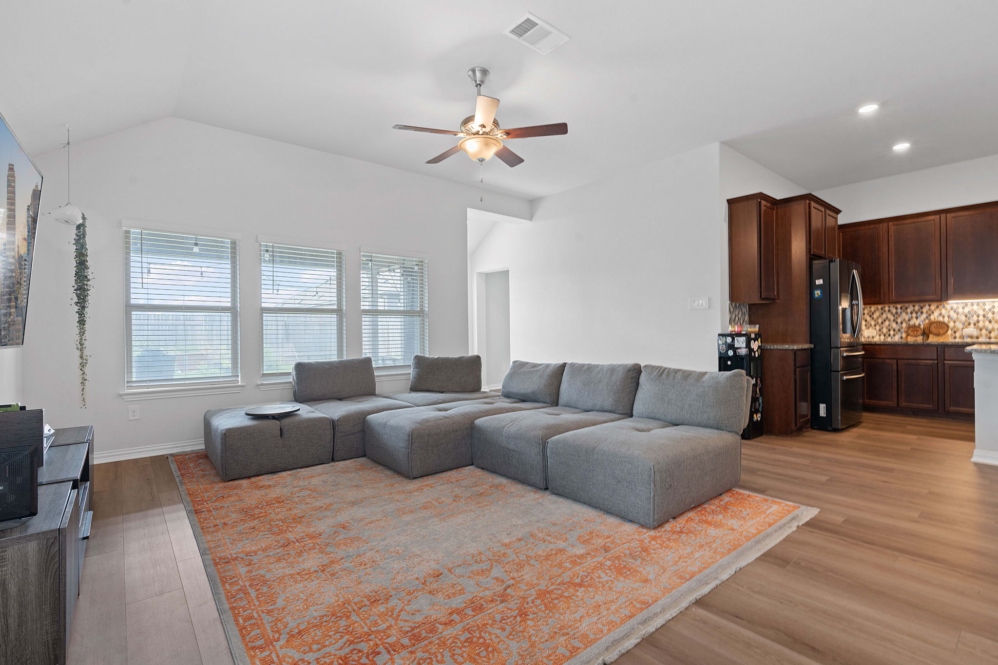 213 Treasure Trove Path Kyle, TX 78640 - Photo 10 of 29 Living room with ceiling fan, light wood-style flooring, and vaulted ceiling