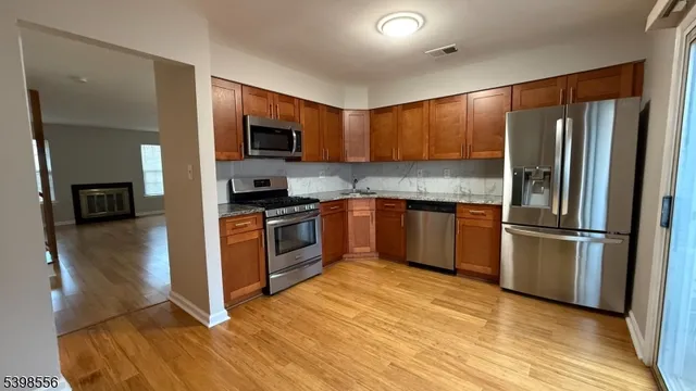 a kitchen with a refrigerator a stove top oven and sink
