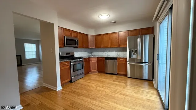 a kitchen with granite countertop a refrigerator and a stove top oven