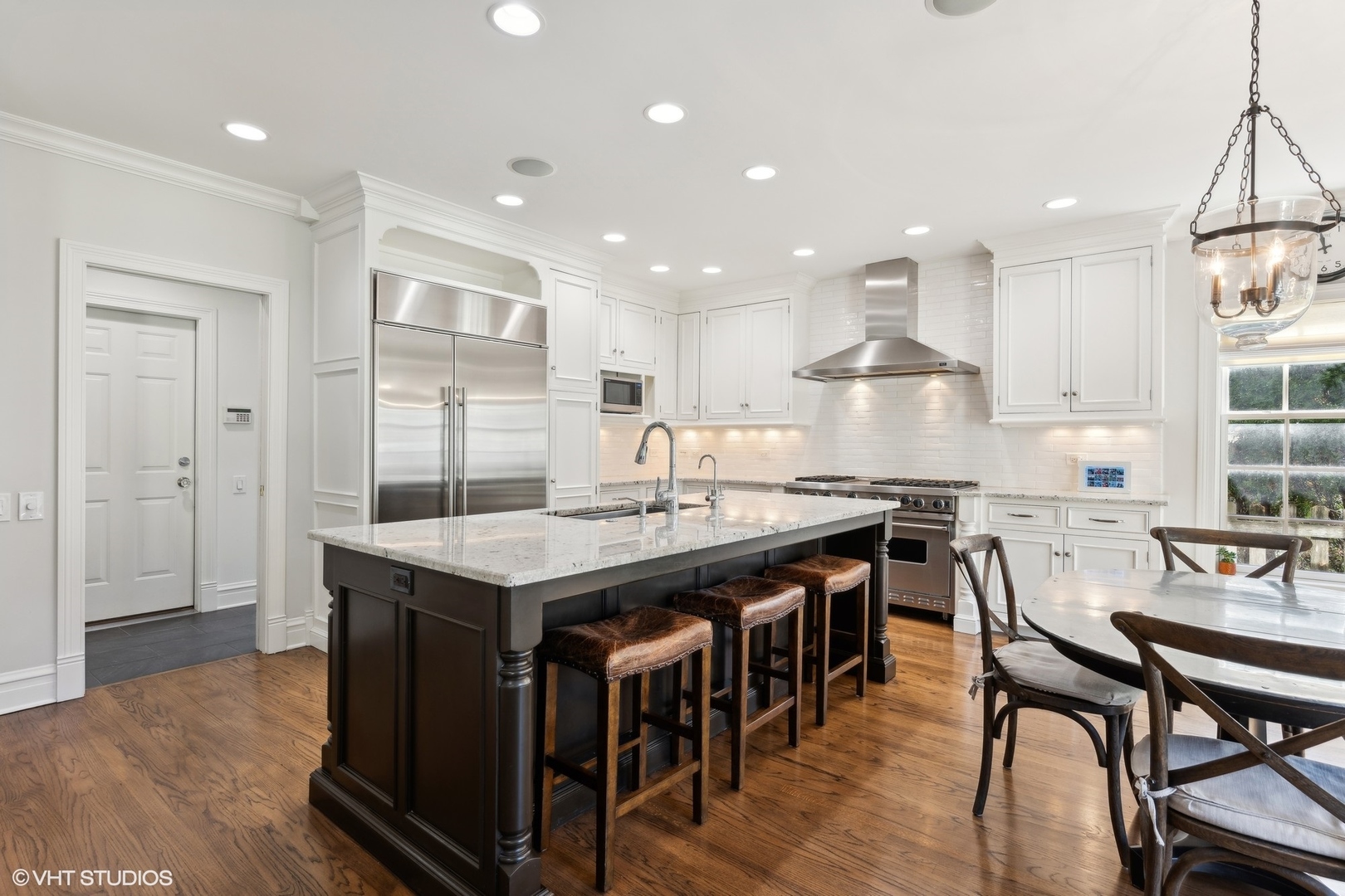 1047 Cherokee Road Wilmette, IL 60091 - Photo 8 of 36 a kitchen with kitchen island granite countertop a table chairs sink and refrigerator