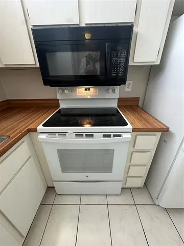 a kitchen with a refrigerator and a stove top oven