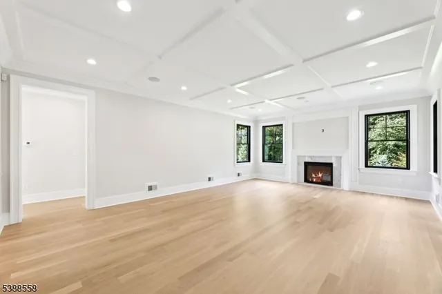 an empty room with windows and fireplace