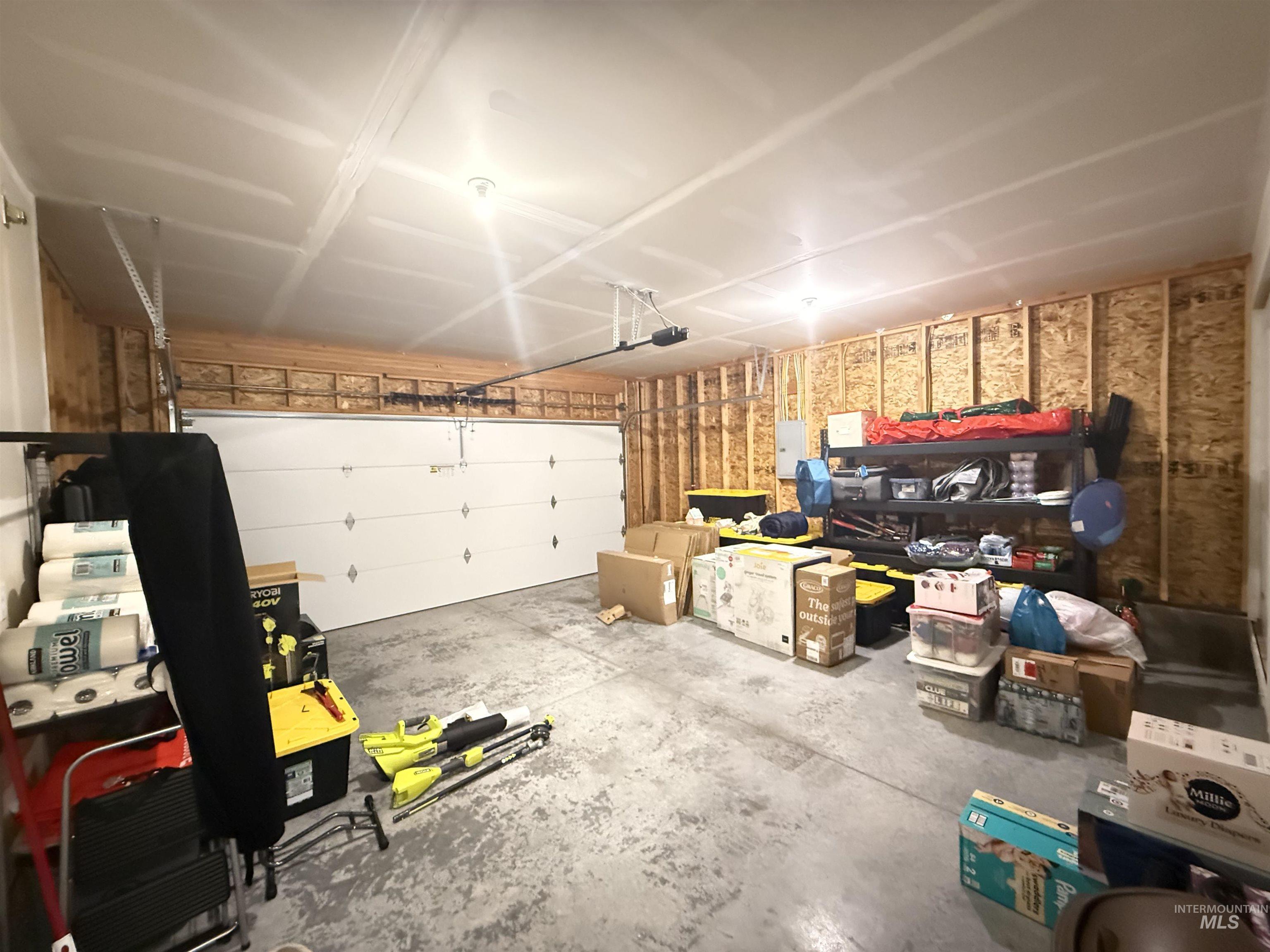 1556 Frontier Drive Lewiston, ID 83501 - Photo 16 of 23 Spacious two-car garage featuring a sectional garage door, exposed wood-frame walls, concrete flooring, and ceiling-mounted lighting
