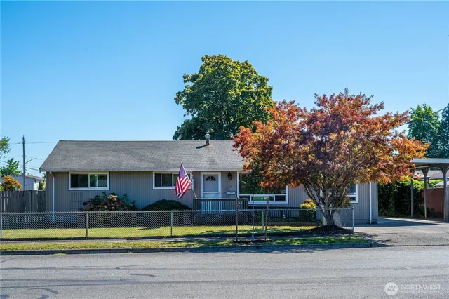 a view of house with a yard and large tree