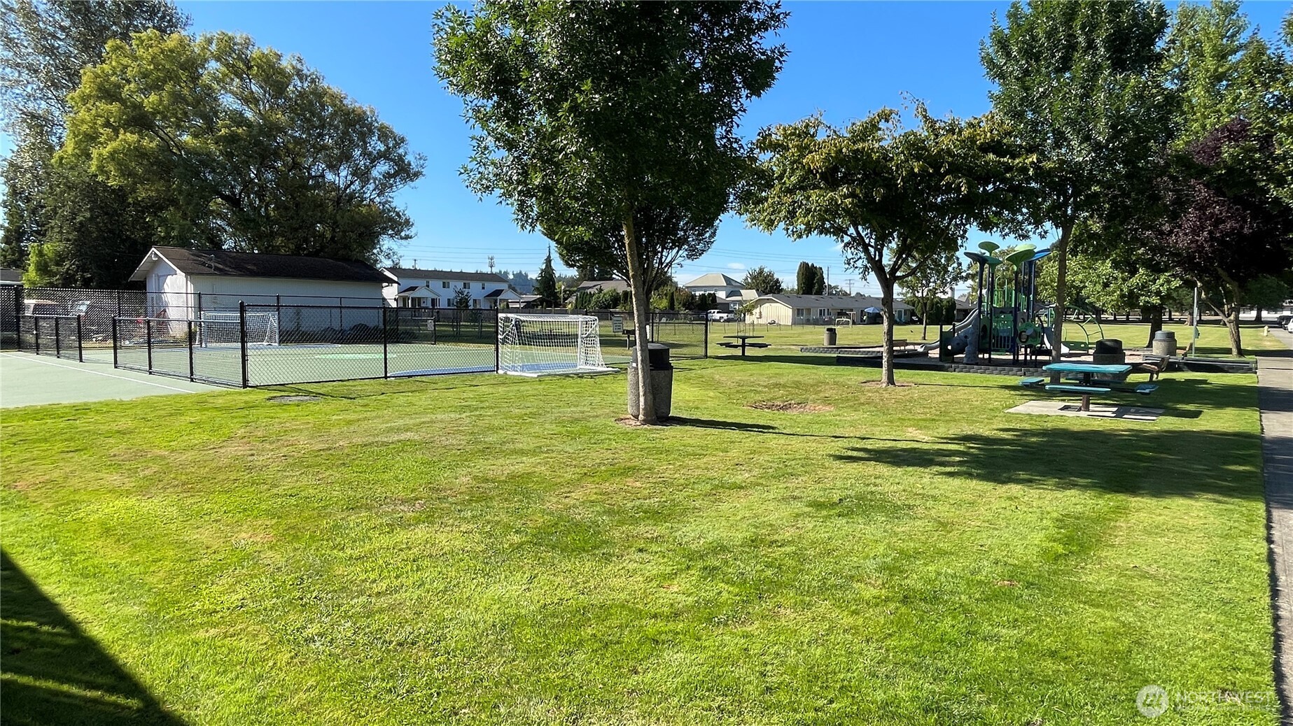 1610 16th Street Sumner, WA 98390 - Photo 27 of 28 a view of a swimming pool with a garden and trees