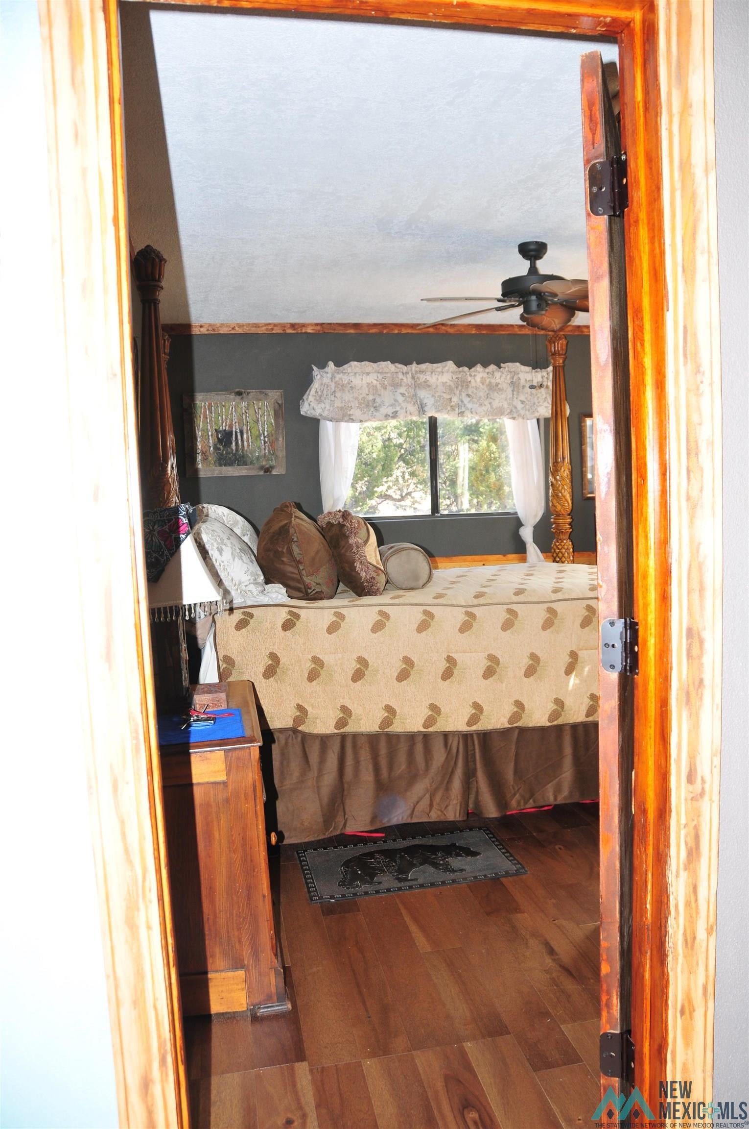 25 Bluff Road Thoreau, NM 87323 - Photo 12 of 31 Room featuring wood-finish flooring, a ceiling fan, and a window with white drapes