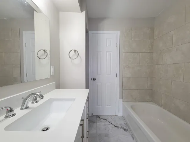 a bathroom with a bathtub a sink and a mirror