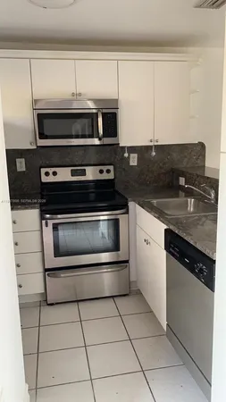 a kitchen with cabinets and steel appliances
