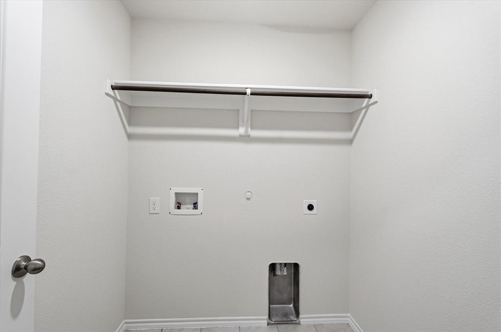 2428 Rosharon Drive Forney, TX 75126 - Photo 14 of 40 Utility room with a built-in shelving unit and clothing rod, featuring dedicated appliance hookups and neutral wall finishes