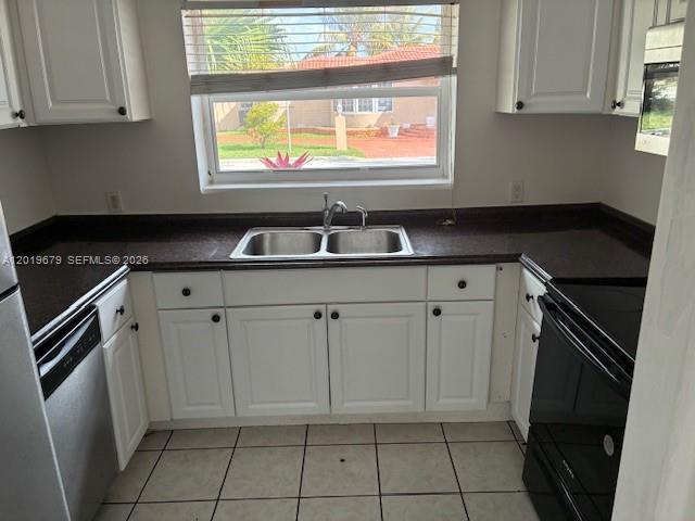 420 88th Street Surfside, FL 33154 - Photo 22 of 33 a kitchen with white cabinets a sink and a stove with wooden floor