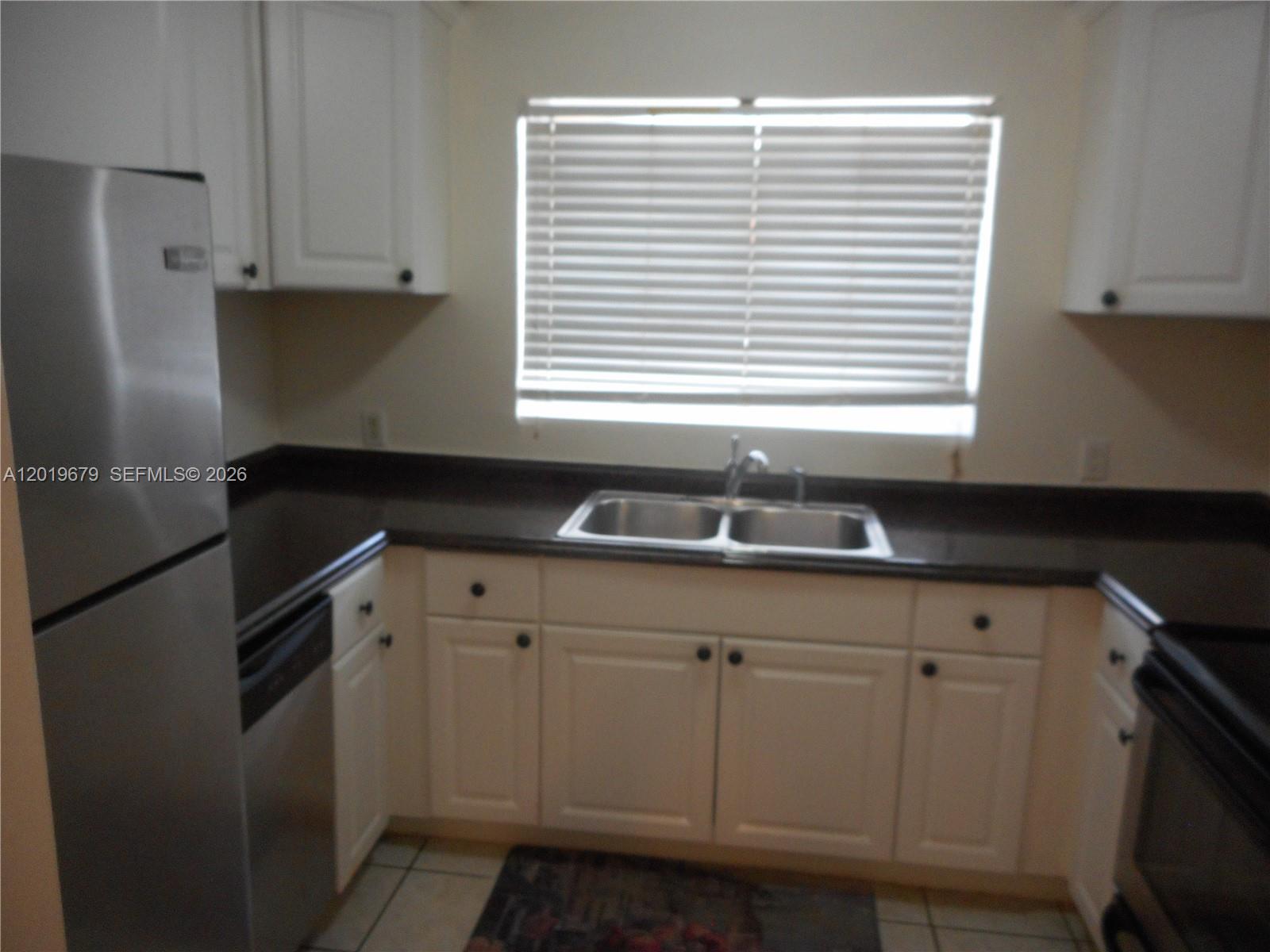 420 88th Street Surfside, FL 33154 - Photo 8 of 33 a kitchen with granite countertop white cabinets and a black umbrella