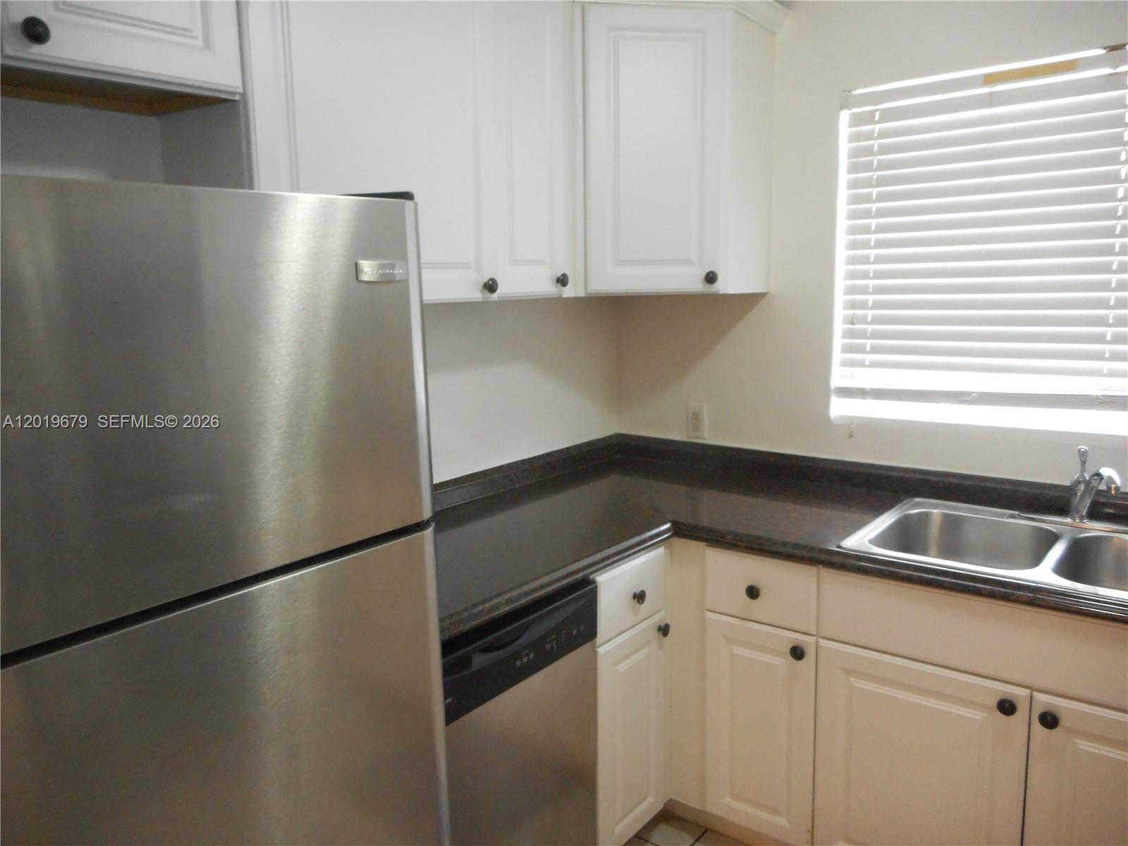 420 88th Street Surfside, FL 33154 - Photo 10 of 33 a kitchen with granite countertop a sink and a refrigerator