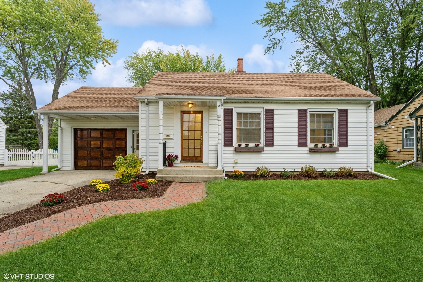 a front view of a house with a garden and yard
