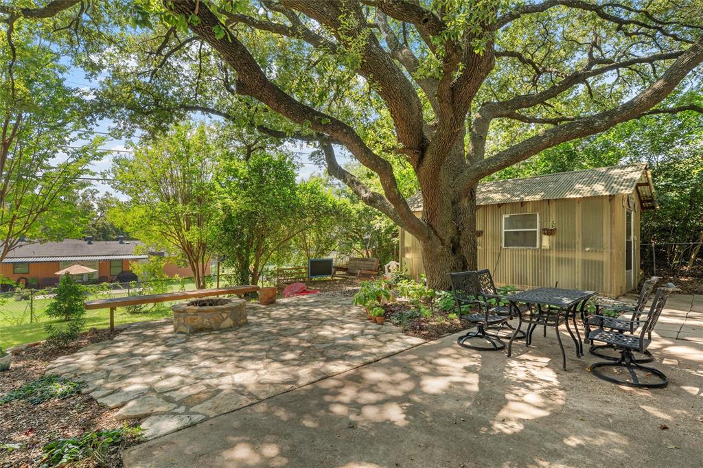 6224 Summit Ridge Drive Waco, TX 76710 - Photo 20 of 25 a backyard of a house with table and chairs under an large trees