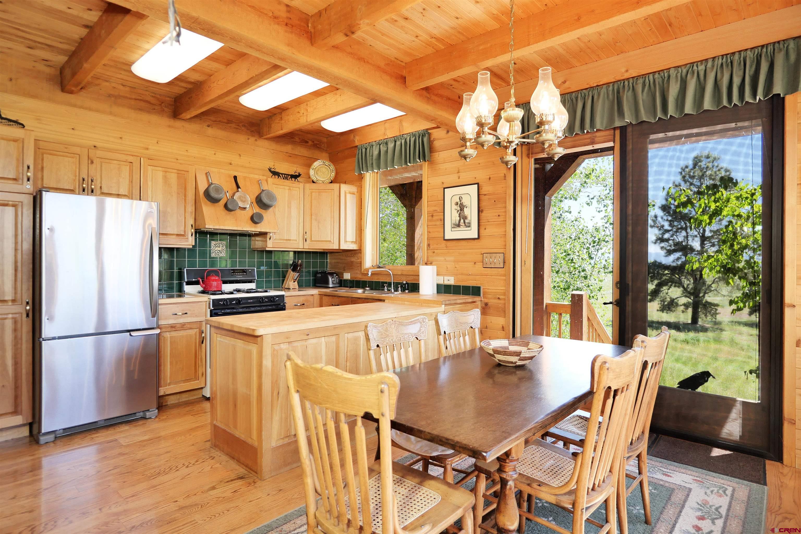 2425 62x Road Placerville, CO 81430 - Photo 13 of 30 a kitchen with stainless steel appliances granite countertop a refrigerator a sink dishwasher a dining table and chairs with wooden floor