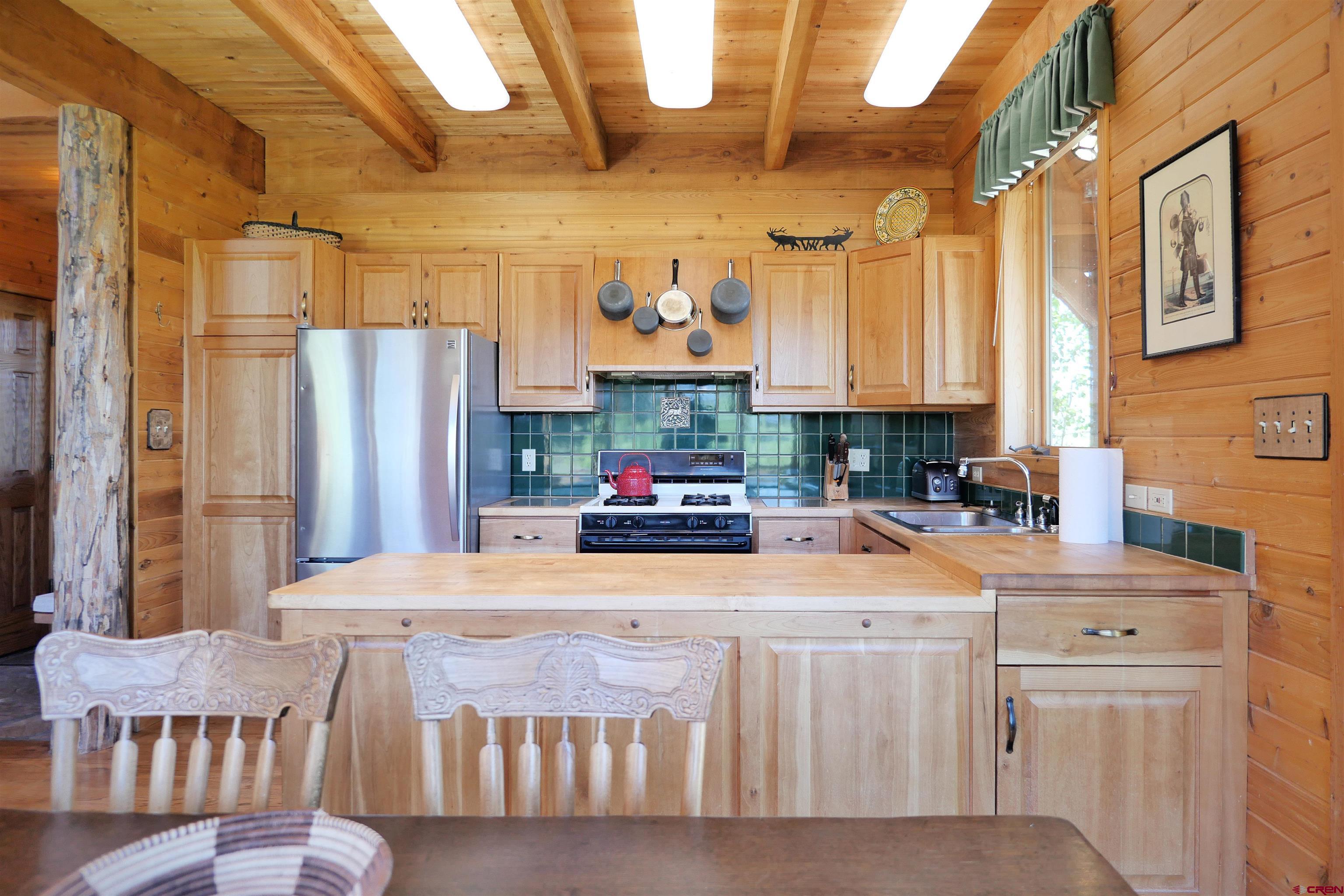 2425 62x Road Placerville, CO 81430 - Photo 16 of 30 a kitchen with stainless steel appliances kitchen island granite countertop a refrigerator a sink a stove and a microwave