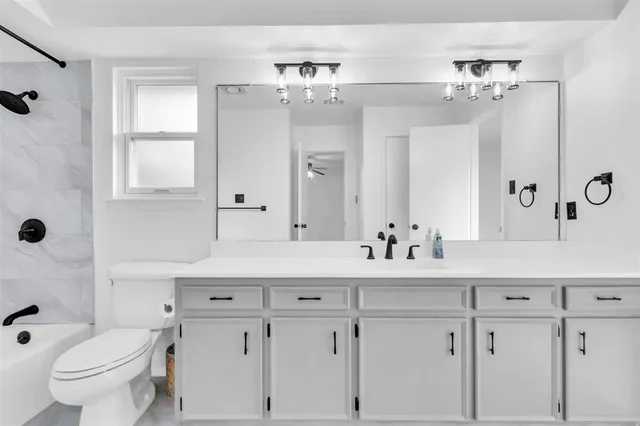 a bathroom with a double vanity sink mirror and toilet