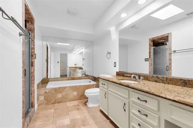 a spacious bathroom with a granite countertop sink mirror and toilet