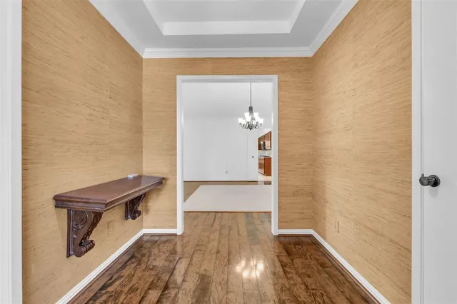 a view of a hallway with wooden floor and a living room