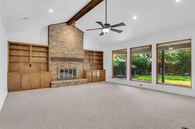 a view of an empty room with a fireplace and a window