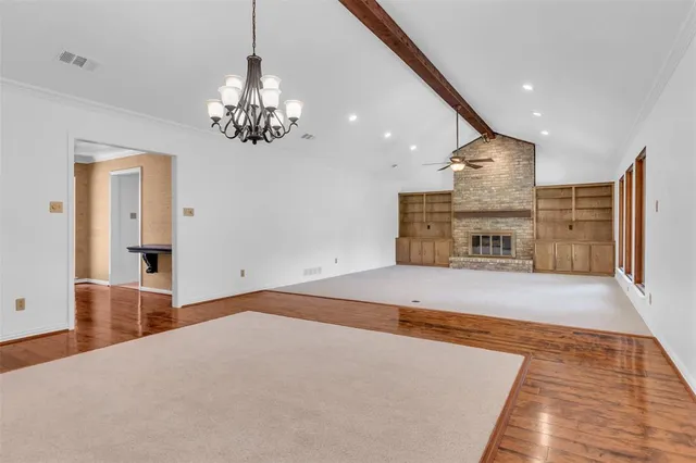 a spacious bedroom with a bed and a chandelier