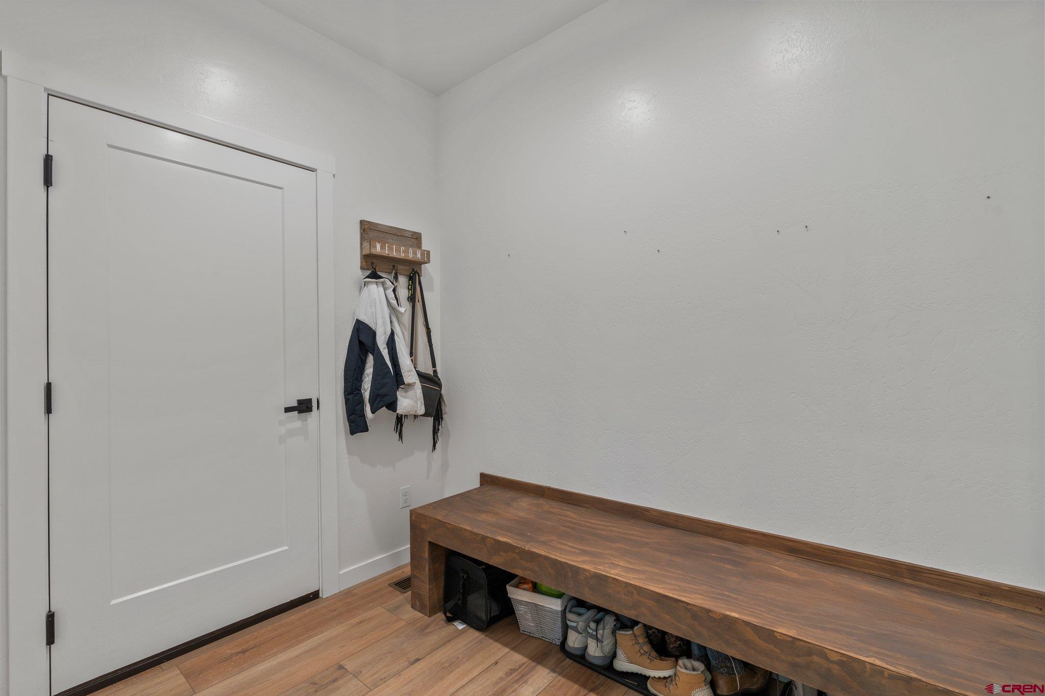 1517 Golf Course Lane Cortez, CO 81321 - Photo 14 of 41 a room with a bench and a wooden floor